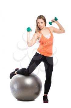 Sporty young woman posing with a fit and dumbbells. Isolated on white