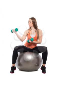 Young beautiful woman doing exercises with dumbbells. Isolated