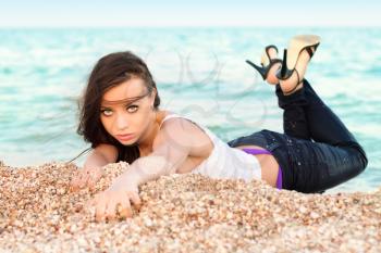 Flirty young brunette lying on the sand