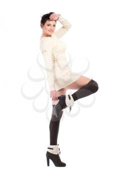 Young brunette wearing white dress, black stockings and boots. Isolated