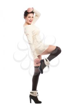 Young smiling brunette wearing white dress, black stockings and boots. Isolated