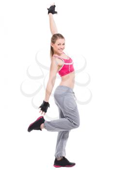 Smiling sporty blond woman wearing gray pants and pink top. Isolated on white
