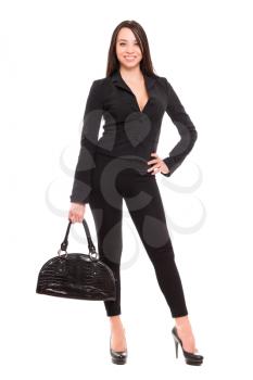 Beautiful young brunette in black clothes with handbag. Isolated on white