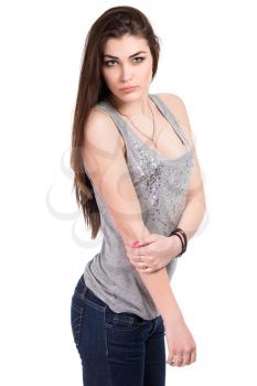 Portrait of pretty brunette posing in blue jeans and grey T-shirt. Isolated on white