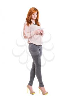 Glamour young woman in tight leggings posing with a phone. Isolated on white