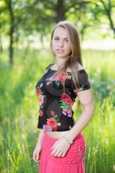 Lovely young woman posing in flowering blouse
