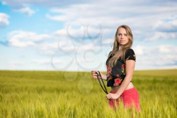 Elegant young woman posing on the wheat field