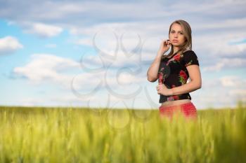 Thoughtful young lady posing on the wheat field