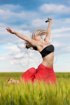 Active young woman posing on the wheat field