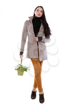 Pretty brunette in brown jeans and coat posing with flowers. Isolated on white