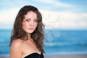 Portrait of pretty young brunette posing on the beach