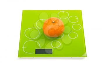 Close-up of sweet mandarin on scales. Isolated