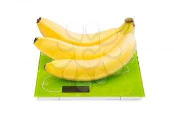 Close-up of three yellow bananas on kitchen scales. Isolated