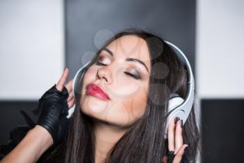 Portrait of pretty young brunette with closed eyes and headphones