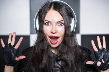 Portrait of playful young woman yelling in headphones