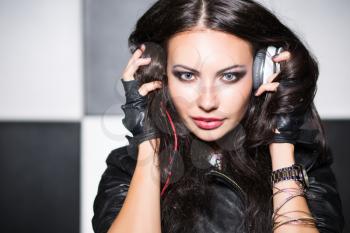 Young woman with headphones posing in the studio