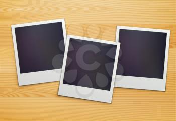 Vector illustration of three blank retro polaroid photo frames over wooden background