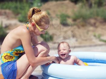 Royalty Free Photo of a Mother Washing Her Son in a Pool