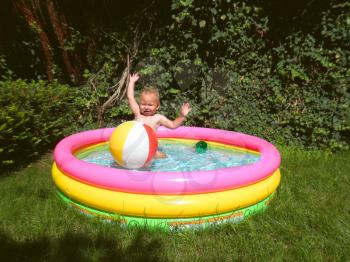 Royalty Free Photo of a Boy Playing in an Inflatable Pool