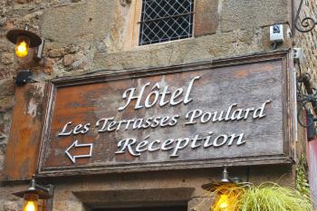 Hotel signboard in the yard abbey of Mont Saint Michel. Normandy, France