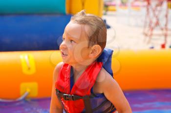 Kid in swimming vest in pool at the water park