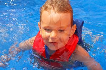 Enthusiastic kid in vest at the pool water park
