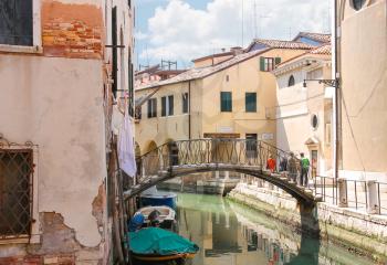 VENICE, ITALY - MAY 06, 2014: Picturesque bridge over a narrow canal in Venice, Italy