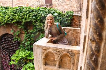 Attractive girl is standing on the balcony of Juliet in Verona, Italy