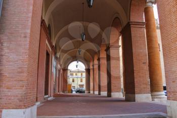 Archway with hanging lanterns of ancient building on Cavour square in Rimini, Italy