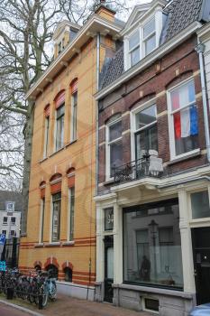 Utrecht, the Netherlands - February 13, 2016: Facade of old building with national flag behind window (Hamburgerstraat)
