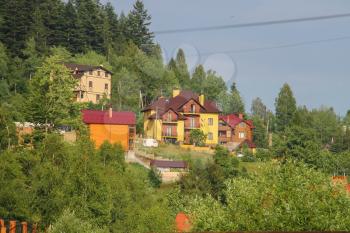 Modern cottages on slope of forested mountains. Carpathians, Ukraine