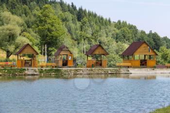 Wooden gazebos on shore of lake in Ukrainian Carpathians