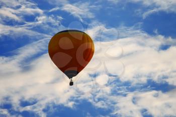 Bright balloon in blue sky with white clouds
