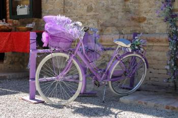 Beautiful purple bicycle with large decorative basket of lavender flowers in front of it