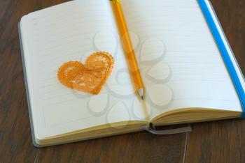 Heart symbol with pencil on open blank notebook page. Love message romance concept. Lyrics loveletter book. 