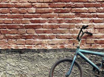 Royalty Free Photo of an Old Bike Against a Brick Wall