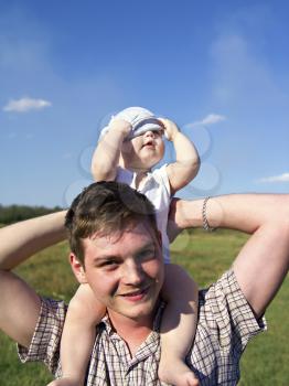 father holds a small child on his shoulders