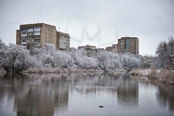 snowy winter city pond on a cloudy day
