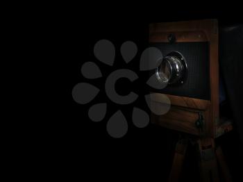 old wooden camera on a tripod  on black background