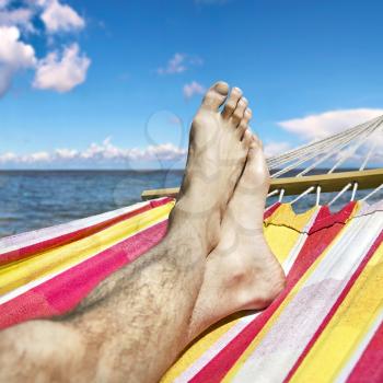 feet in the hammock against the sea