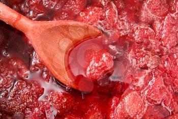Royalty Free Photo of a Wooden Spoon in Strawberry Jam