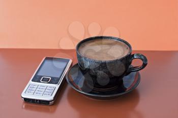 Royalty Free Photo of a Coffee Cup and Cellphone