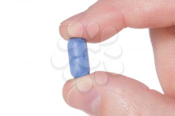 Hand holding a blue pill close up. Isolated on white background 