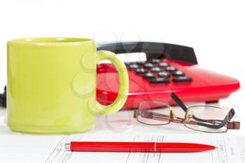 Pen, glasses, telephone and coffee cup on the desk