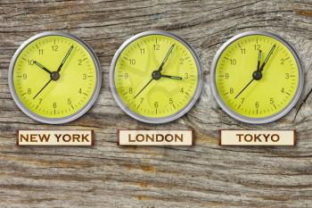 World time. Time in  New York, London and Tokyo, three watches on wooden wall