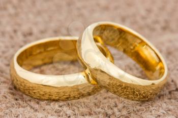 Pair of golden wedding rings on the burlap