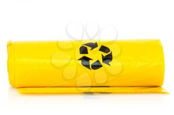 Yellow garbage bio bags in a roll on white background