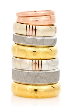 Golden and silver rings stacked on a white background