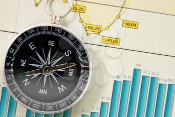 Compass on the background of economic growth charts 