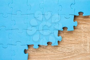 Blue puzzle on wooden background.Teamwork concept